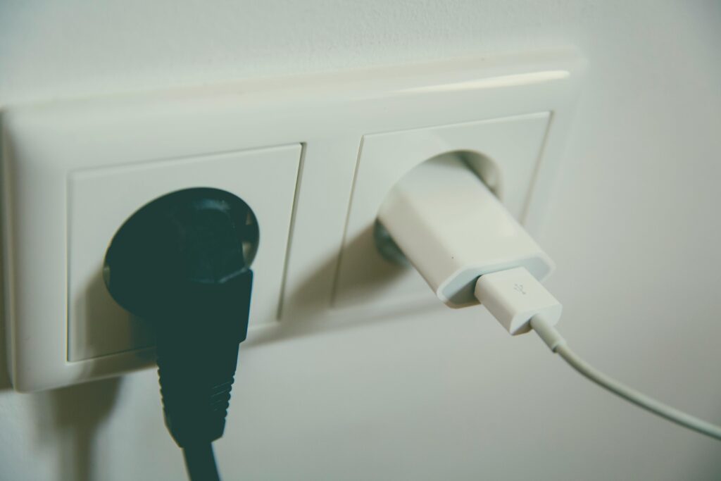 A close-up view of a wall outlet with two plugs inserted, capturing the simplicity of electrical connectivity.